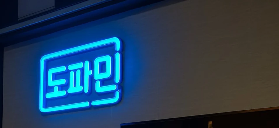 푸른 네온으로 빛나는 도파민 매장 간판